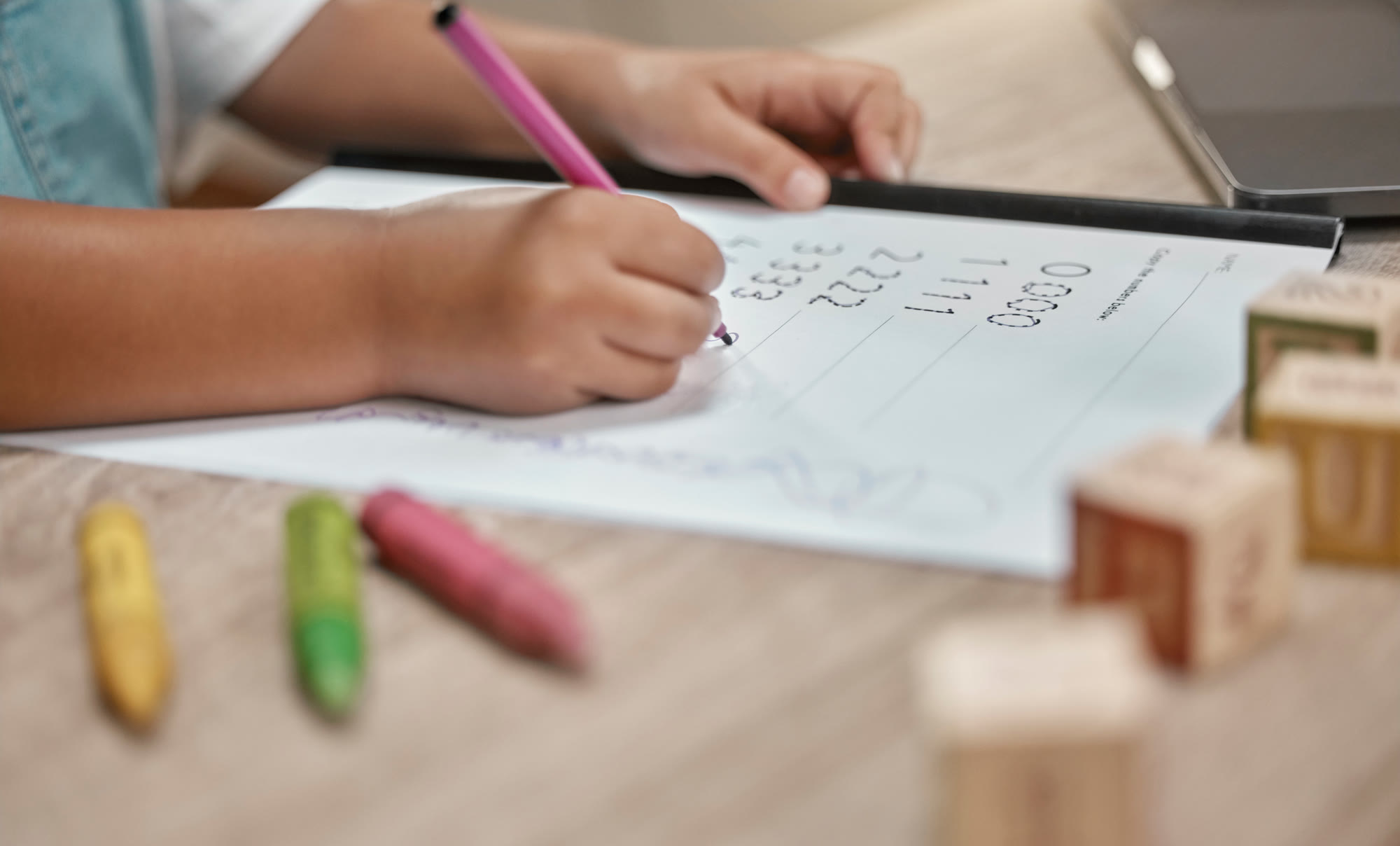 A child working with blocks and a pencil
